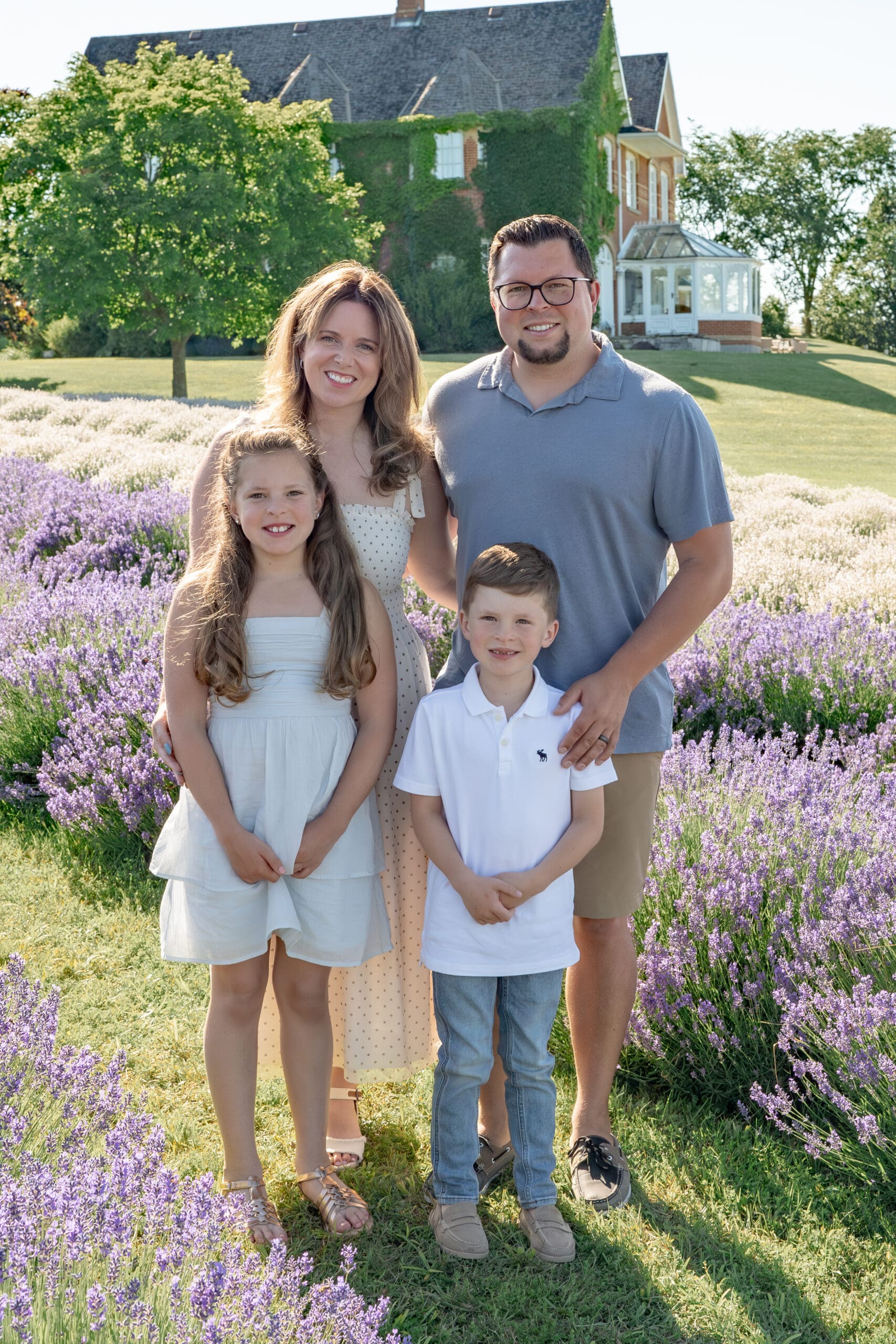 Family smiling in lavender field — photographed by Alliston and Barrie maternity, newborn, and family photographer.
