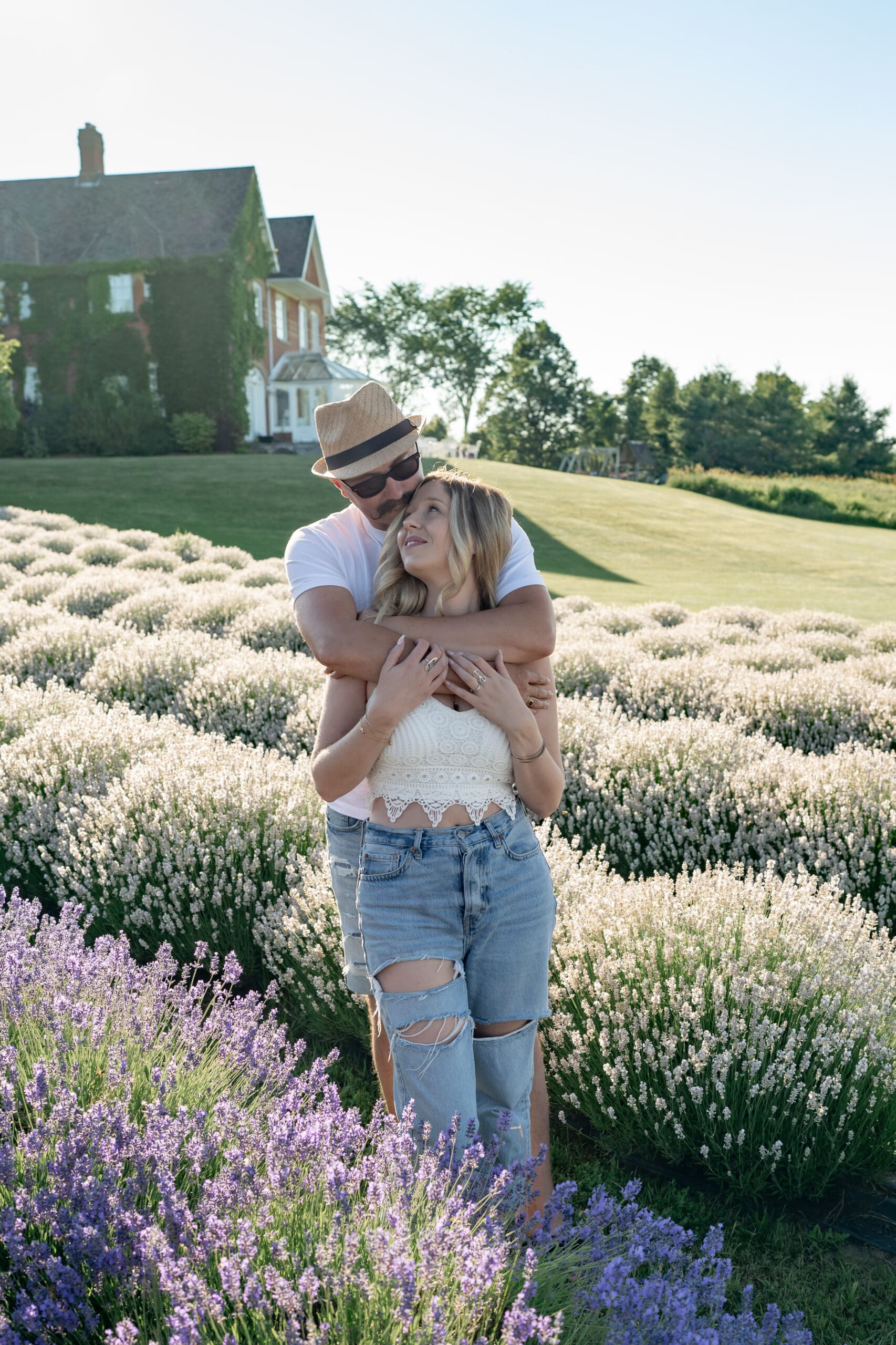 Couple embracing in lavender field — photographed by Alliston and Barrie maternity, newborn, and family photographer.