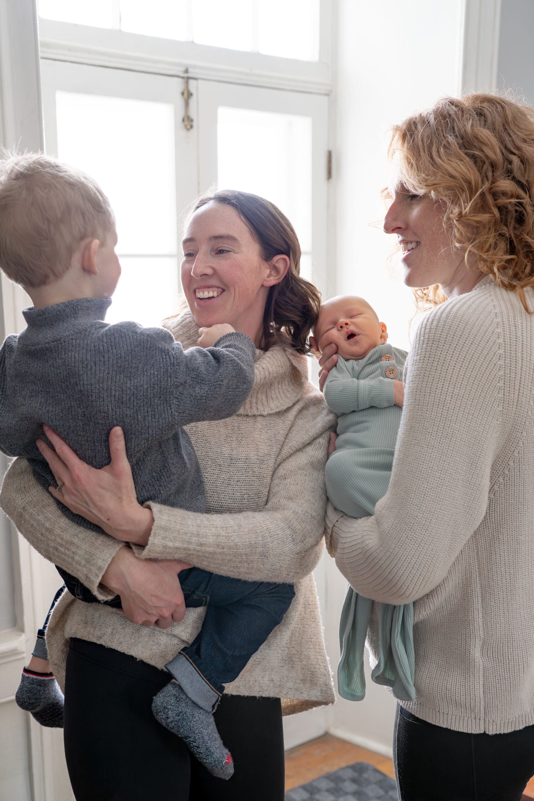 Lifestyle newborn session with two mothers holding their children, a toddler and a newborn — captured by Alliston and Barrie maternity, newborn, and family photographer.