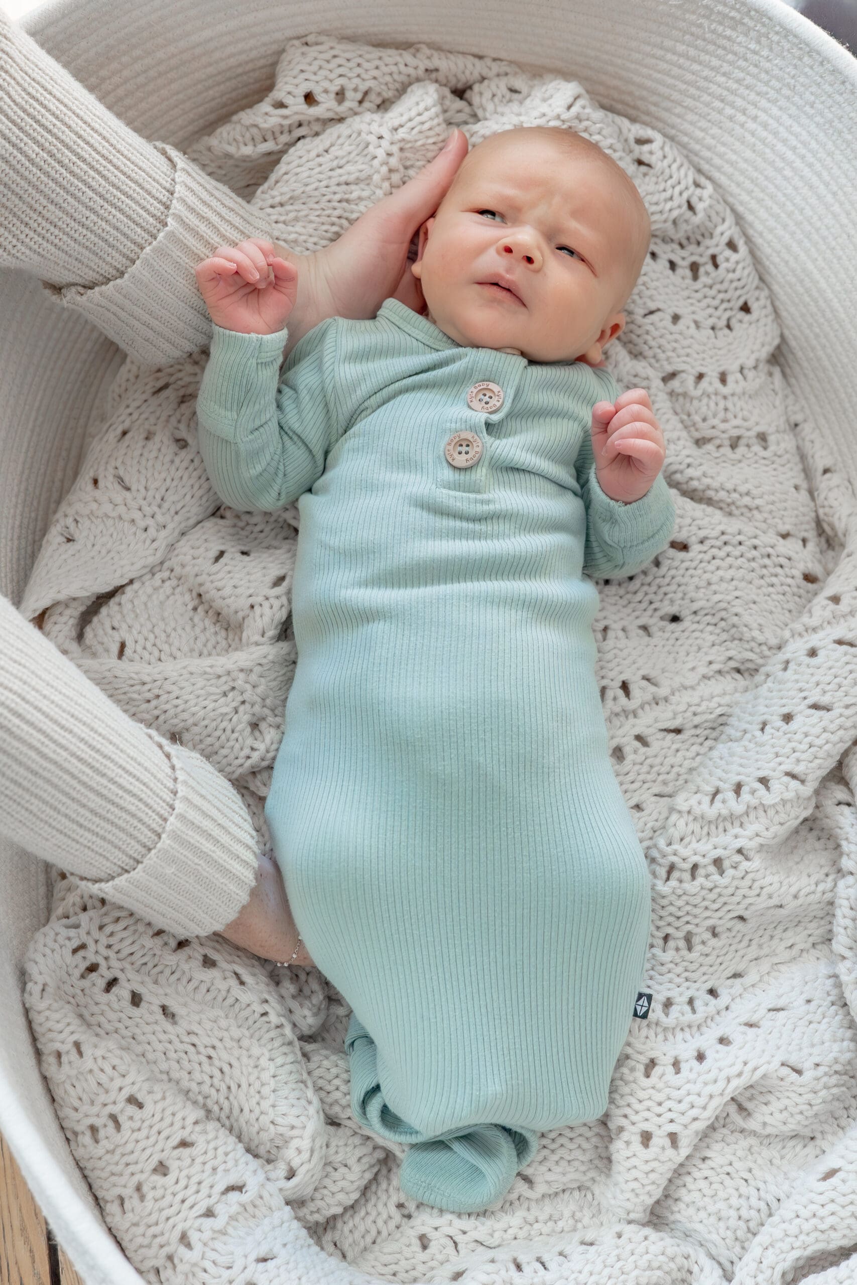 Lifestyle newborn session with baby being picked up from basket — captured by Alliston and Barrie maternity, newborn, and family photographer.