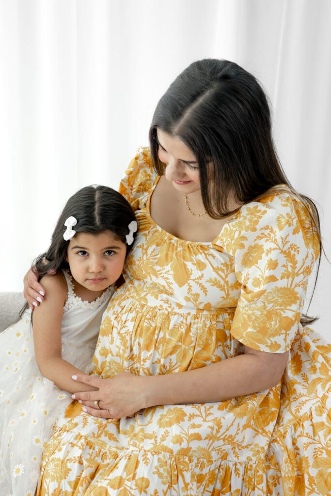 Expecting mother hugging toddler during a soft, natural light maternity session — photographed by Alliston and Barrie maternity, newborn, and family photographer.