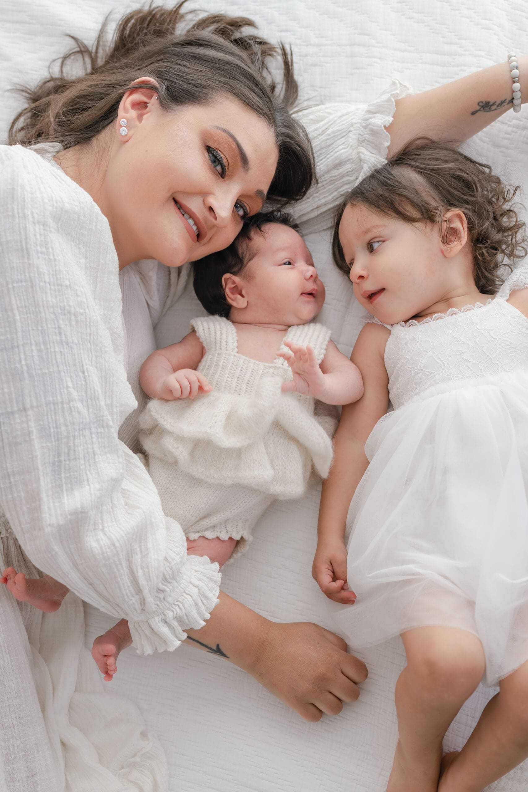 Alliston newborn photographer captures parents and siblings in bright studio setting


