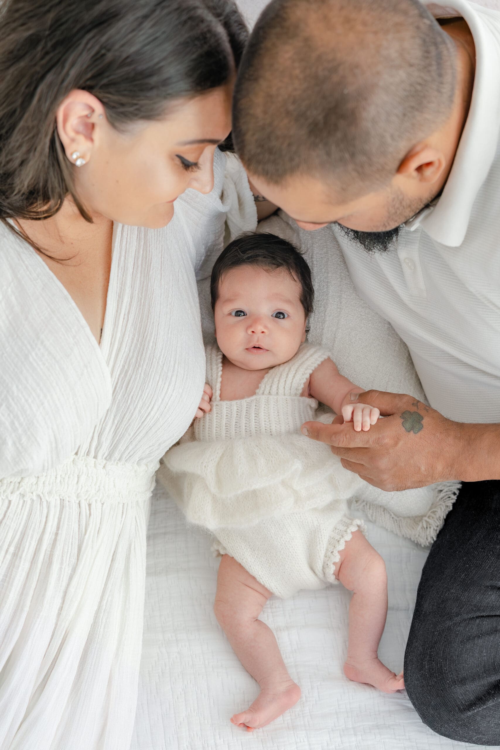 Alliston newborn photographer captures parents and siblings in bright studio setting

