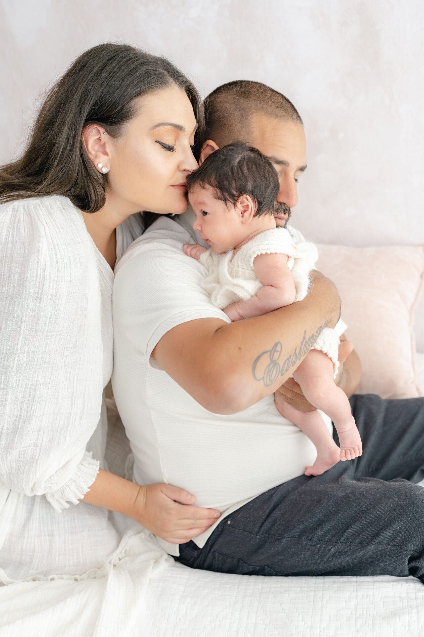 Alliston newborn photographer captures parents and siblings in bright studio setting


