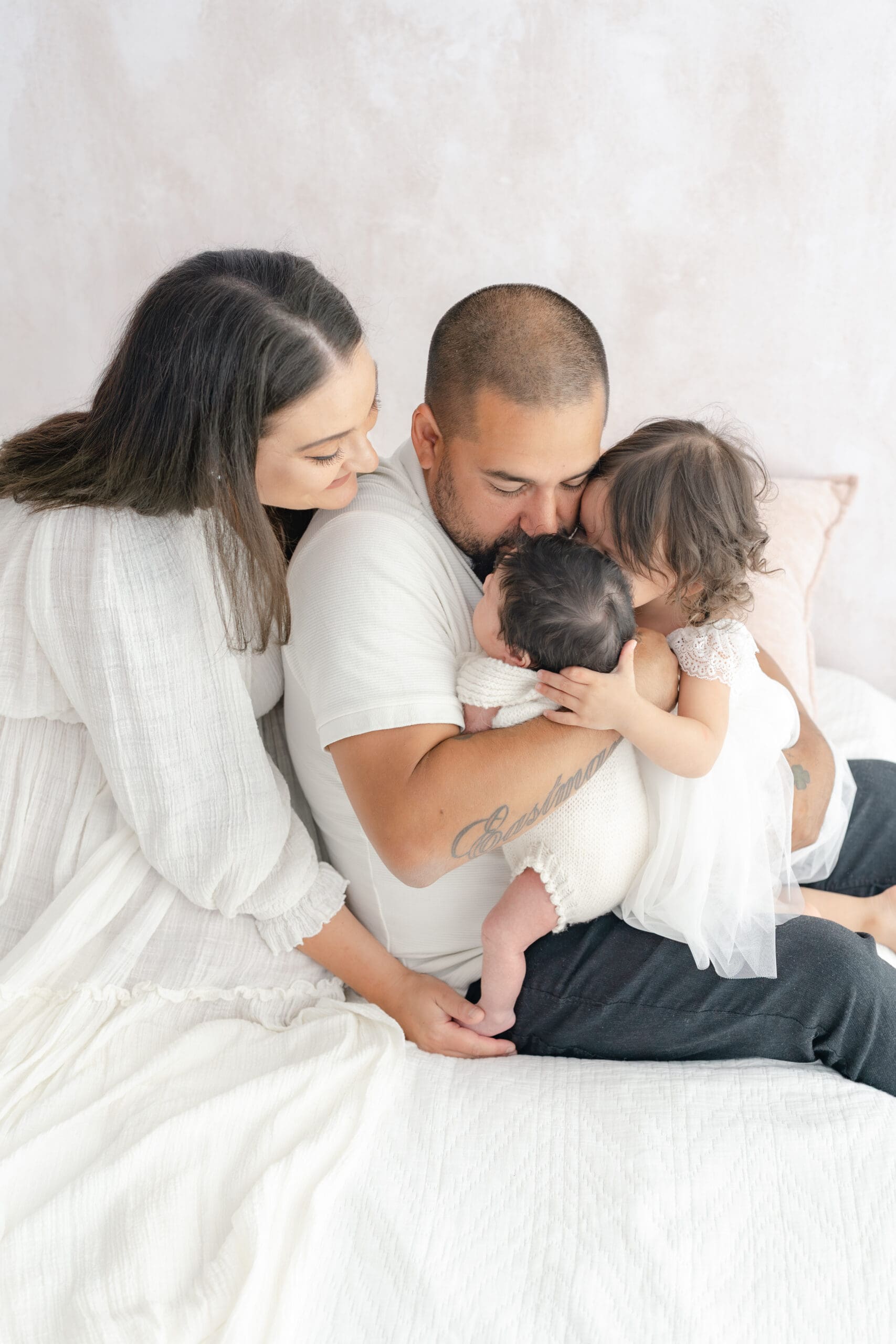 Alliston newborn photographer captures parents and siblings in bright studio setting