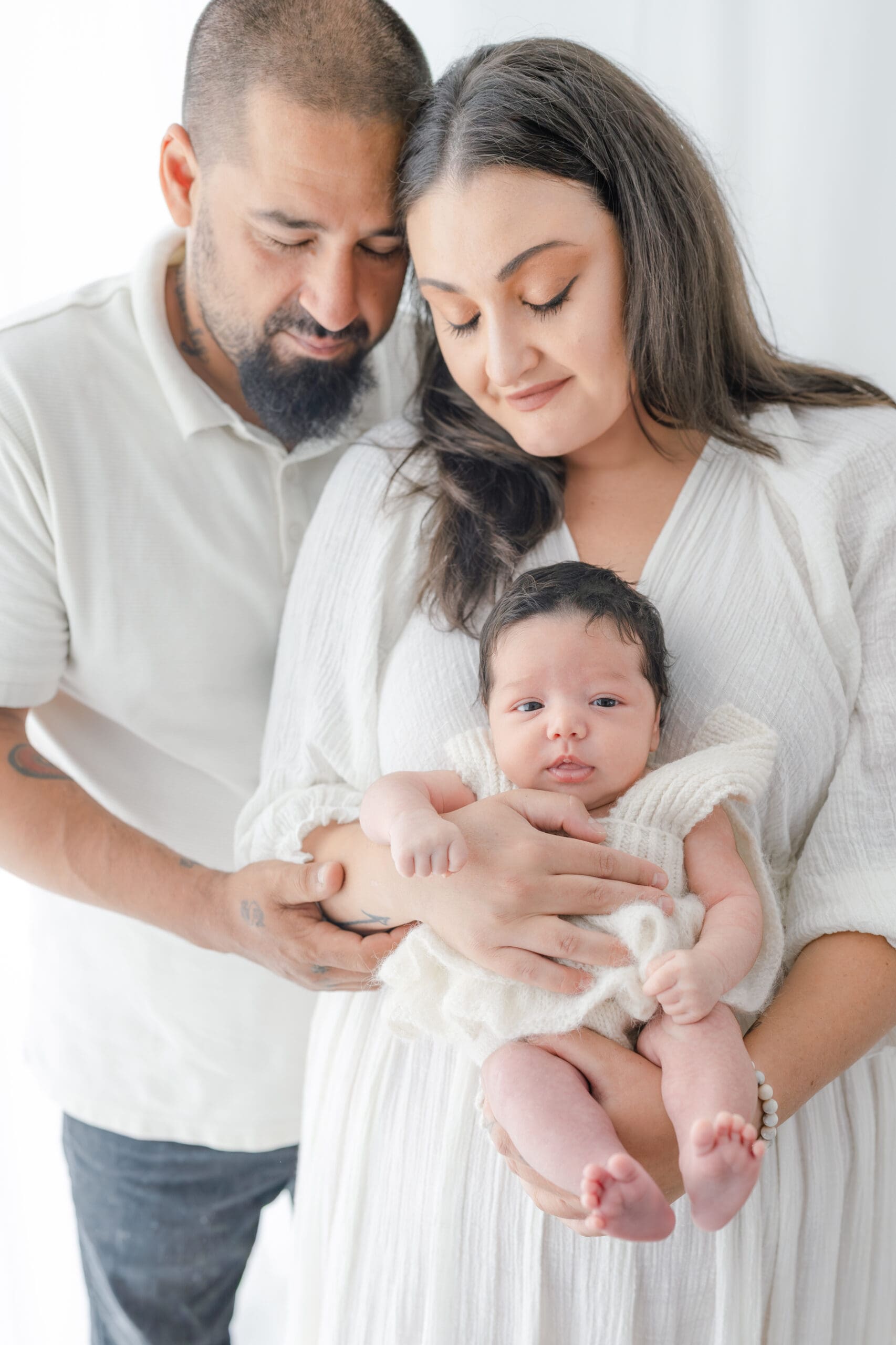 Alliston newborn photographer captures parents and siblings in bright studio setting

