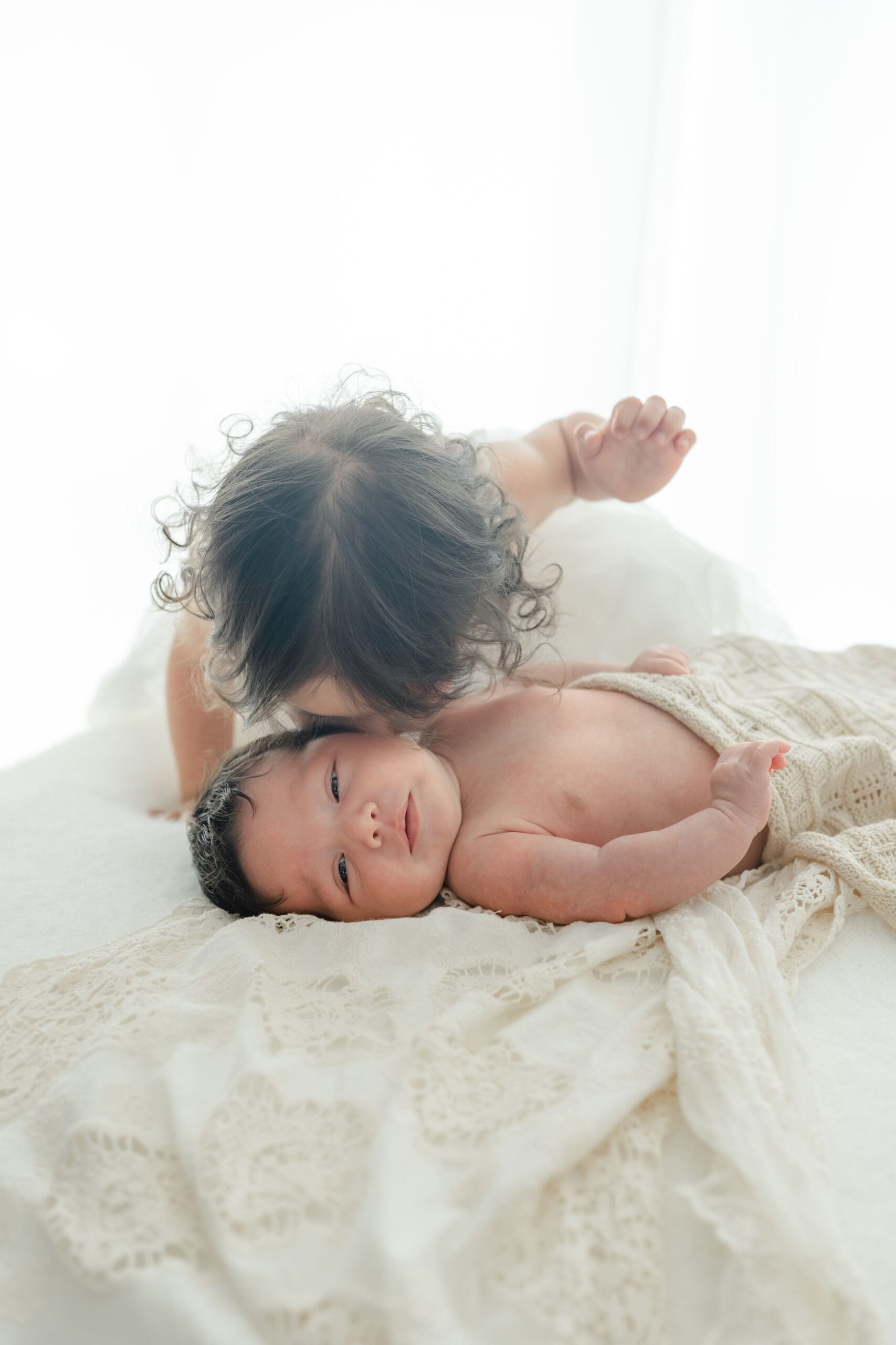 Alliston newborn photographer captures parents and siblings in bright studio setting

