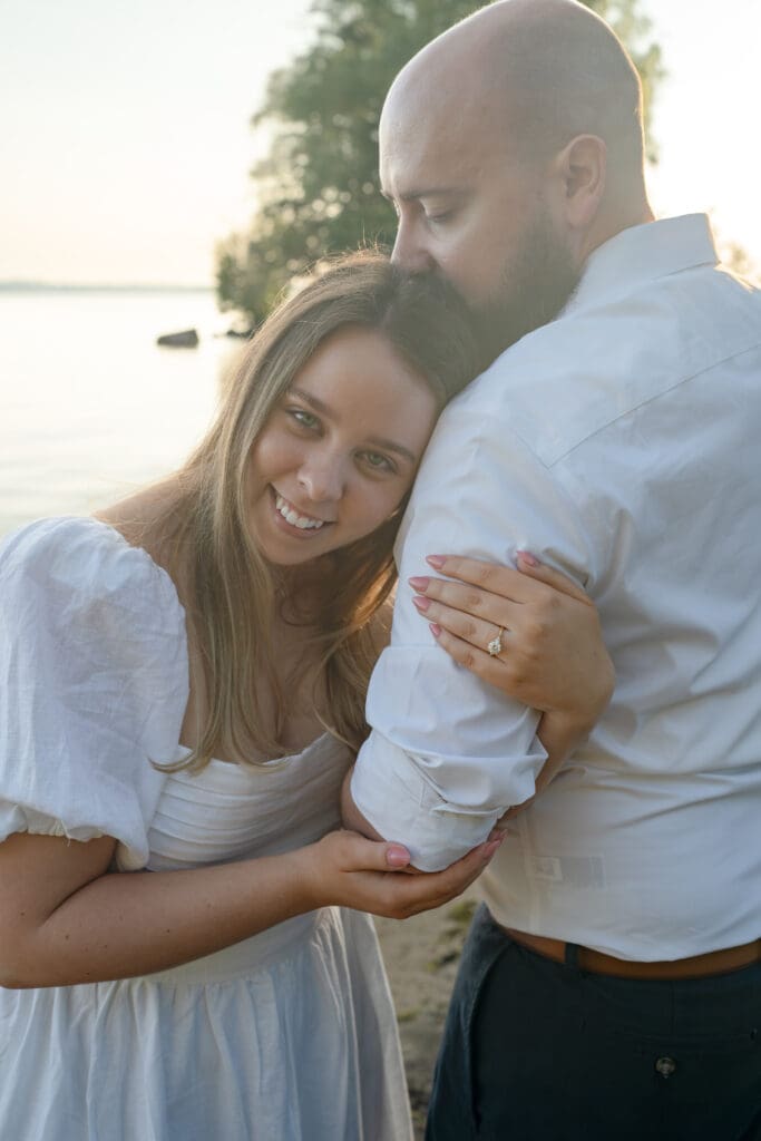 Couple hugging on beach during family photography session in Barrie
