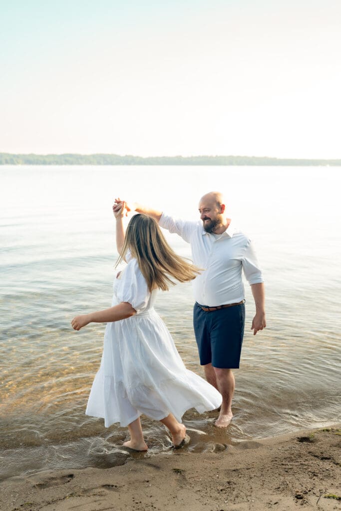 Couple dancing on beach during family photography session in Barrie