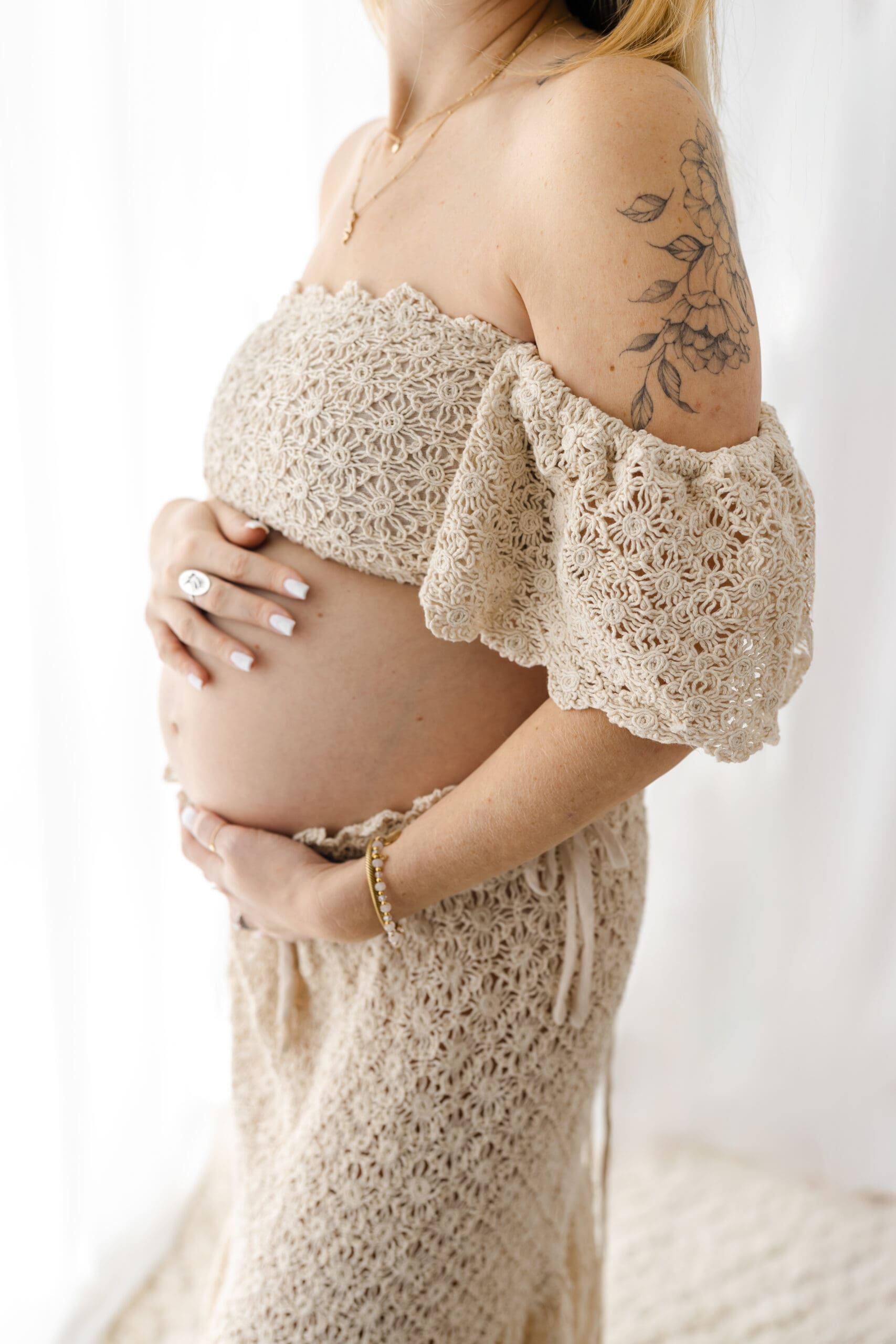 Fine art maternity session in Barrie featuring mom in two-piece gown holding bump